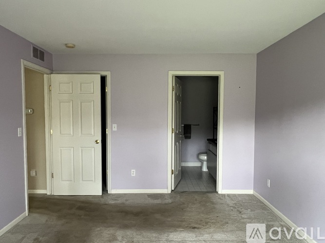 A room with a toilet in the other room is visible through an open door.