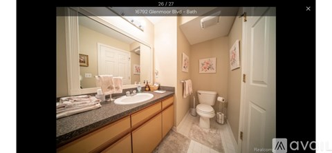 A bathroom with a toilet, sink, and mirror.