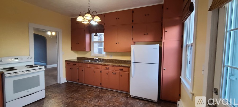 A kitchen with brown cabinets and a white fridge.