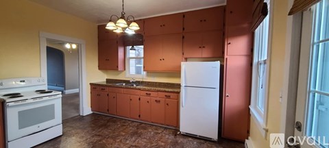 A kitchen with brown cabinets and a white fridge.