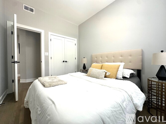 A bedroom with a large bed and a white headboard.