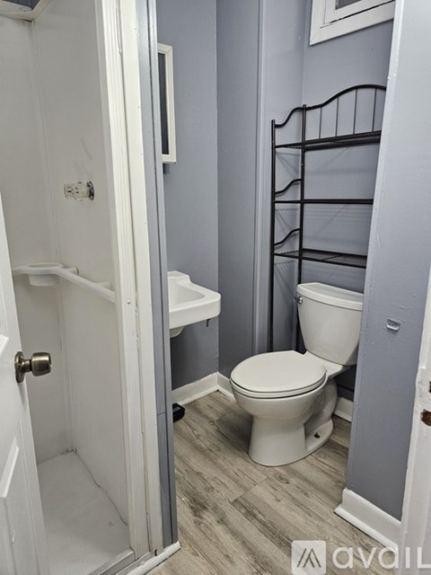 A white toilet in a bathroom with a white door.