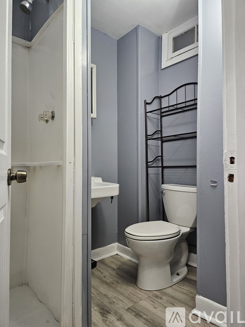 A white toilet in a bathroom with grey walls.