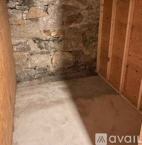 A room with a stone wall and wooden framing.