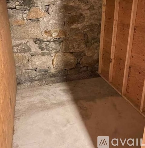 A room with a stone wall and wooden framing.