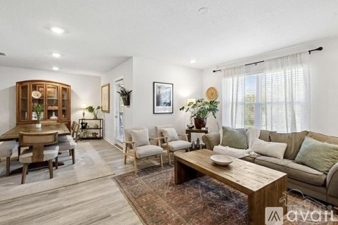 A living room with a wooden coffee table and a couch with green cushions.