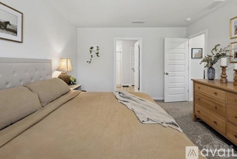 A bedroom with a large bed and a wooden dresser.