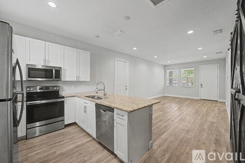 A kitchen with white cabinets and a wooden island.