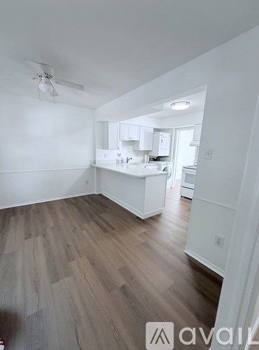 A room with a ceiling fan and wooden flooring.