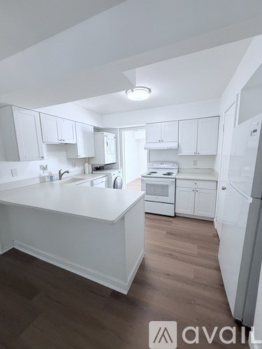 A kitchen with white cabinets and a white island.