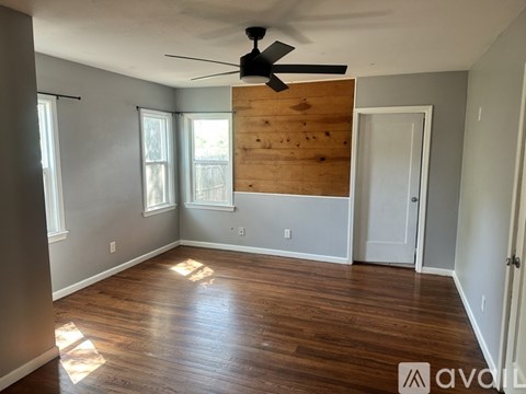 A room with wooden floors and a ceiling fan.