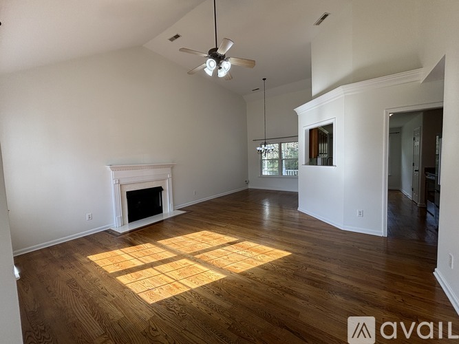 A living room with a fireplace and wood flooring.