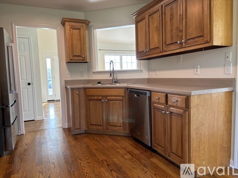 A kitchen with wooden cabinets and a black fridge.