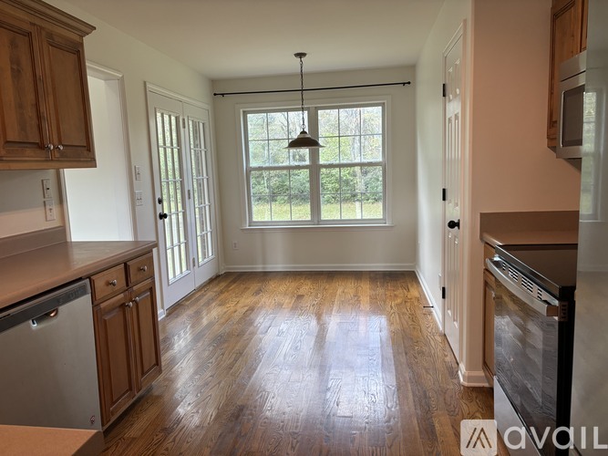 A kitchen with wooden cabinets and a large window.