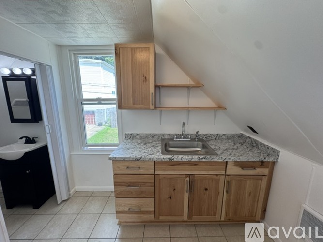 A kitchen with a marble countertop and wooden cabinets.
