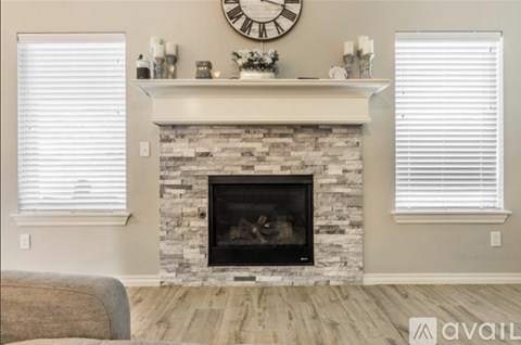A fireplace with a clock above it and a couch in front of it.
