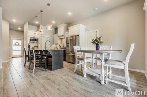 A kitchen with a dining table and chairs.