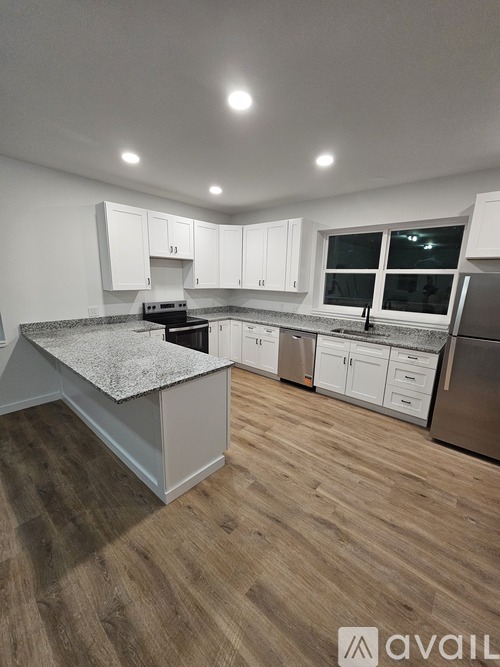 A kitchen with white cabinets and a granite countertop.