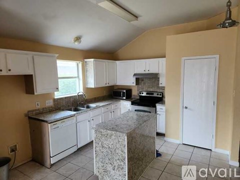 A kitchen with white cabinets and a granite countertop.
