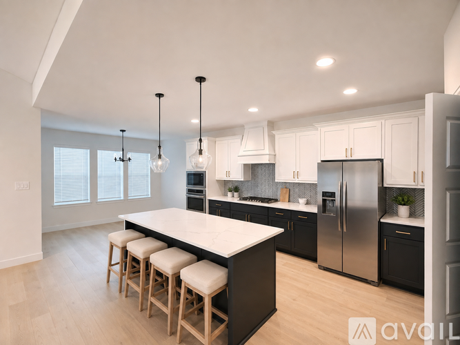 A modern kitchen with a large island and stools.