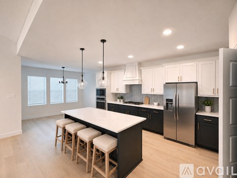 A modern kitchen with a large island and stools.