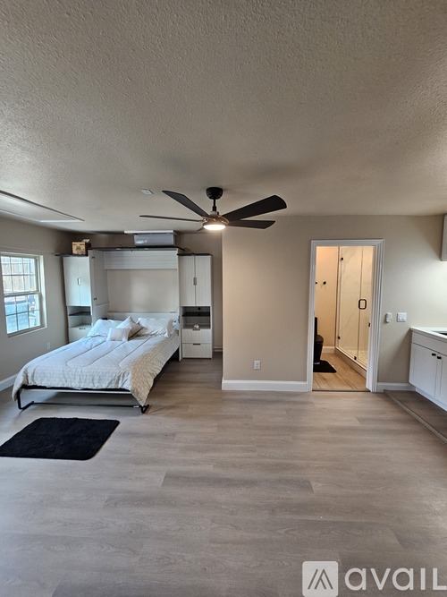 A bedroom with a bed, dresser, and ceiling fan.