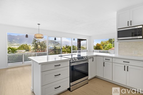 A kitchen with white cabinets and a stove top oven.