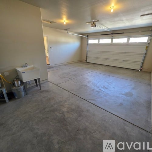 A spacious garage with a white sink and a window.