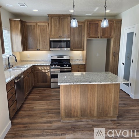 A kitchen with wooden cabinets and a marble countertop.