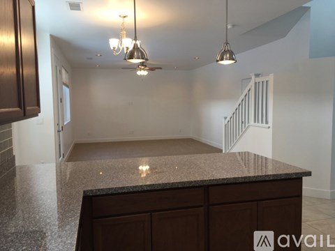 A kitchen with a granite countertop and wooden cabinets.