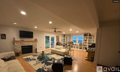 A living room with a fireplace and a television on the wall.