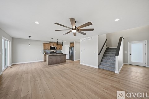 A spacious room with a ceiling fan and wooden flooring.