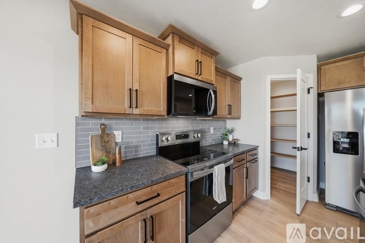 A kitchen with wooden cabinets and a black countertop.