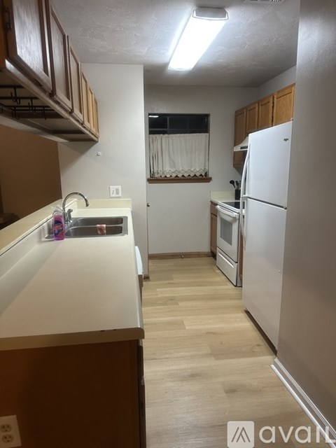 A kitchen with wooden cabinets and a white fridge.