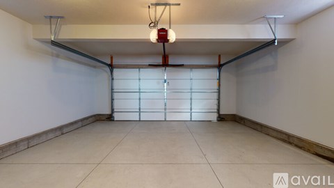 A spacious garage with a white floor and a white wall.