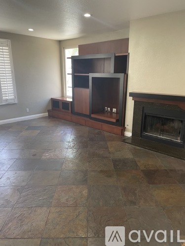 A living room with a fireplace and a television.