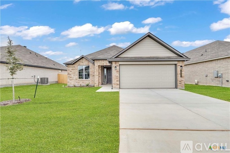 A house with a garage door and a driveway in front.