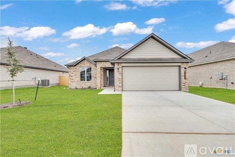 A house with a garage door and a driveway in front.