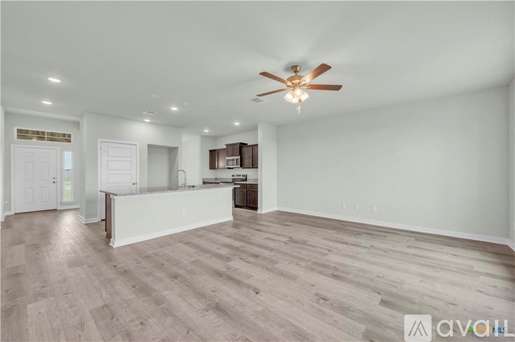 A spacious room with a ceiling fan and lighting fixtures.