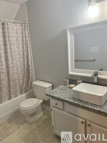 A bathroom with a toilet, sink, and shower curtain.