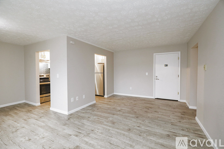 A spacious room with a wooden floor and white walls.