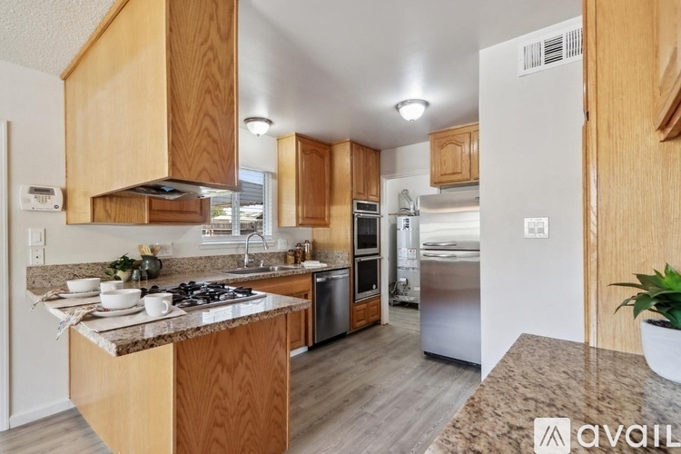 A kitchen with wooden cabinets and a granite countertop.