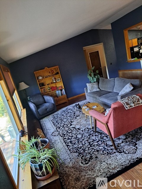 A living room with a red chair and a grey couch.