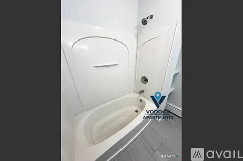 A white bathtub with a faucet and a shower head.
