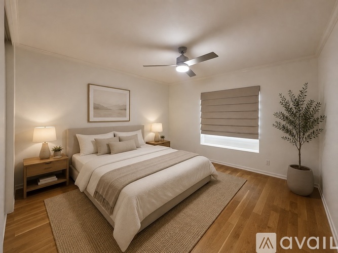 A bedroom with a large bed and a ceiling fan.