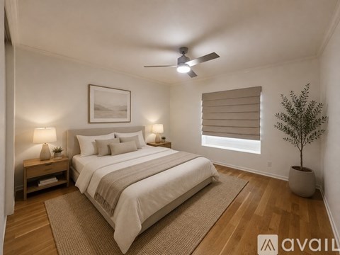 A bedroom with a large bed and a ceiling fan.