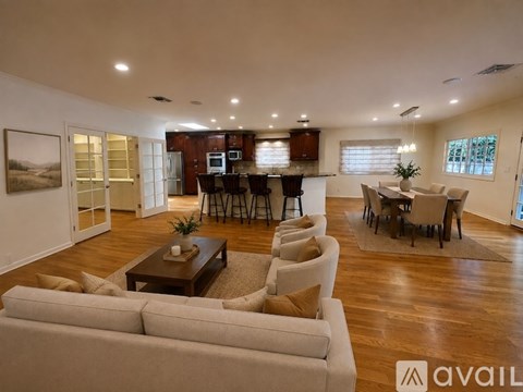 A spacious living room with a couch, coffee table, and a dining area with a table and chairs.