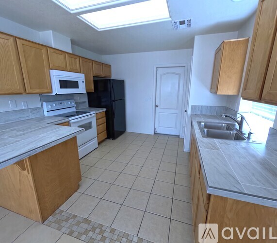 A kitchen with wooden cabinets and black appliances.
