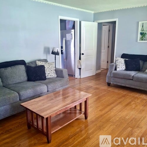A living room with a grey couch and a wooden coffee table.