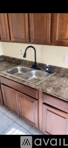 A kitchen with brown cabinets and a stainless steel sink.